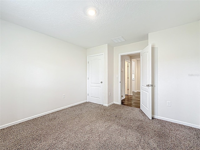 19 Roxland Ln, Palm Coast, FL 32164 - unfurnished bedroom with carpet flooring, a textured ceiling, and baseboards
