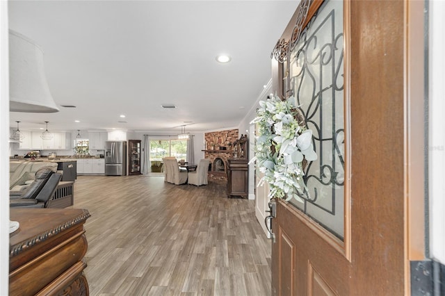 entryway with a fireplace, recessed lighting, light wood-style flooring, and visible vents