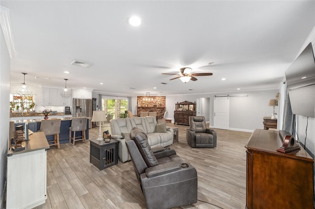 living area featuring a barn door, light wood finished floors, a ceiling fan, recessed lighting, and visible vents