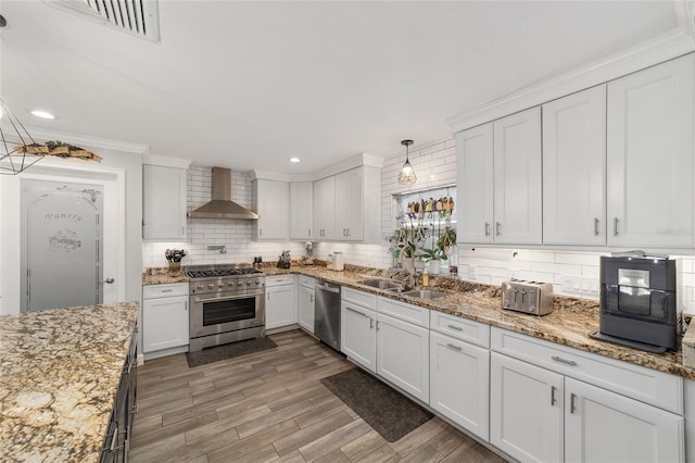 kitchen featuring white cabinetry, backsplash, wall chimney range hood, and stainless steel appliances