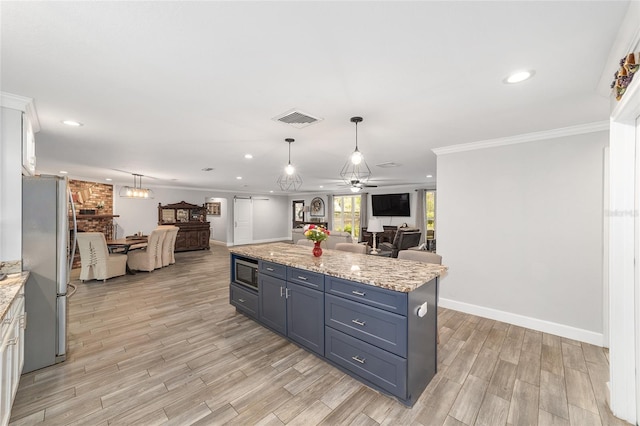 kitchen featuring ornamental molding, stainless steel appliances, open floor plan, and visible vents