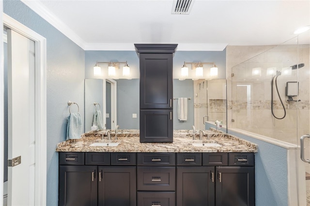 full bath with a sink, a shower stall, double vanity, and visible vents