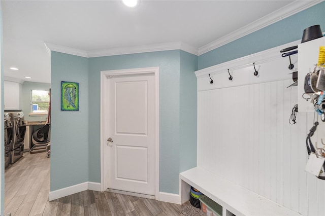 mudroom featuring baseboards, washer and clothes dryer, light wood-style flooring, and ornamental molding