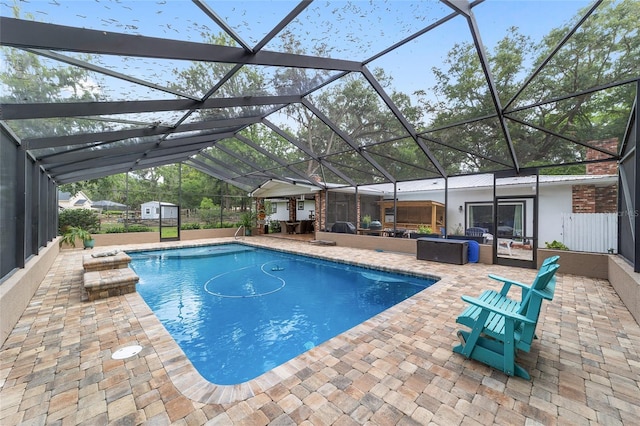 pool with glass enclosure, an outbuilding, a shed, and a patio area