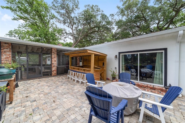 view of patio / terrace with a sunroom and outdoor dry bar