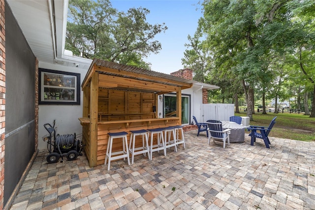 view of patio with fence and outdoor dry bar
