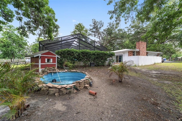view of pool with an outdoor structure and glass enclosure