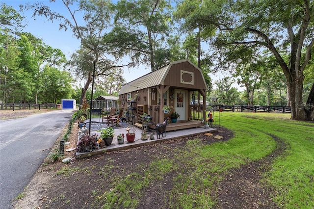 exterior space featuring fence, an outbuilding, and a lawn