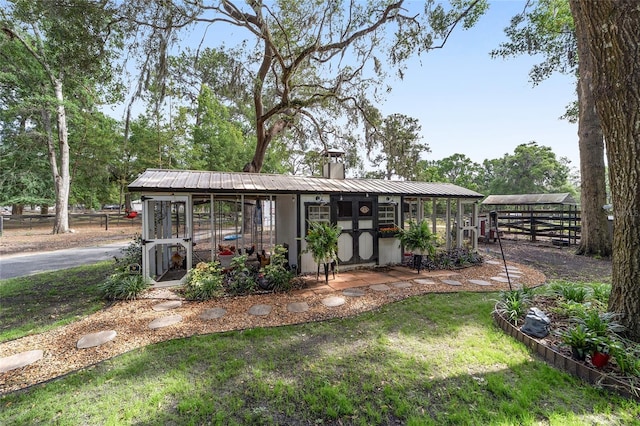 view of front of property with an outdoor structure, exterior structure, fence, and a chimney