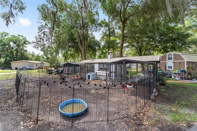 view of front of property featuring an outdoor structure, exterior structure, and fence