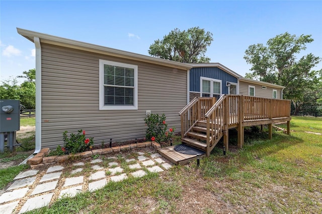 rear view of property with a lawn and a wooden deck