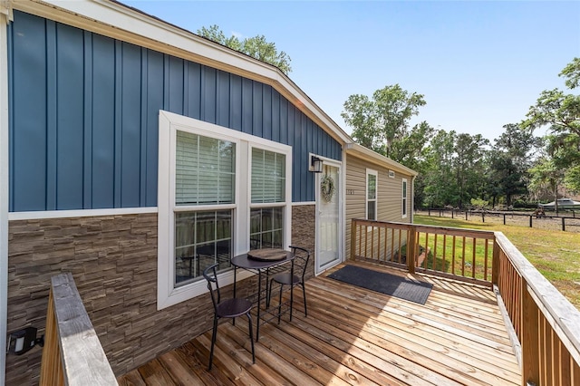 wooden deck with a lawn and fence