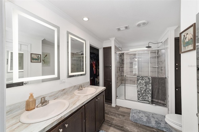 bathroom featuring crown molding, visible vents, a sink, and a stall shower