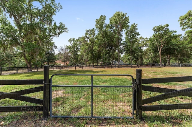 view of gate featuring fence and a lawn