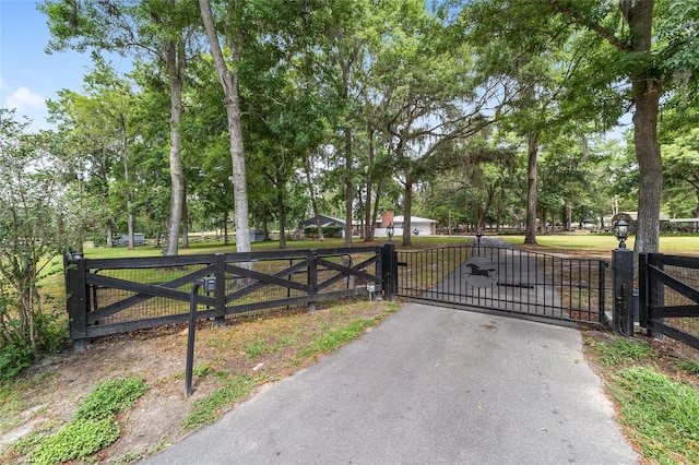 view of gate with a yard and fence