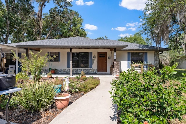 408 Etheredge St, Bushnell, FL 33513 - ranch-style home featuring stucco siding, stone siding, covered porch, and roof with shingles