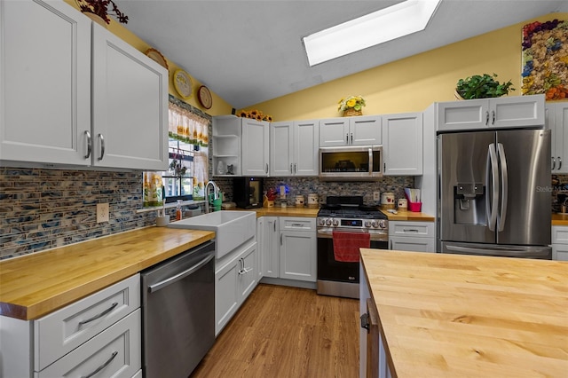 408 Etheredge St, Bushnell, FL 33513 - kitchen with butcher block counters, stainless steel appliances, a sink, lofted ceiling, and a skylight