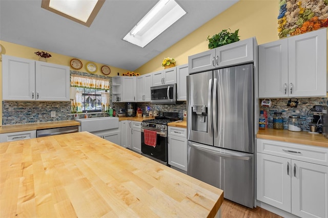 408 Etheredge St, Bushnell, FL 33513 - kitchen featuring butcher block counters, appliances with stainless steel finishes, a sink, vaulted ceiling, and backsplash