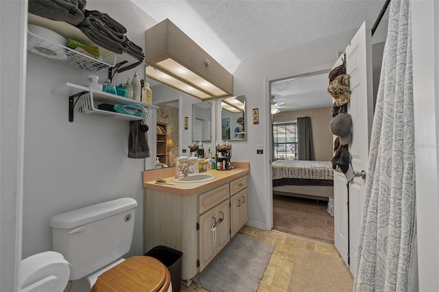 408 Etheredge St, Bushnell, FL 33513 - ensuite bathroom with toilet, stone finish flooring, a textured ceiling, vanity, and a ceiling fan