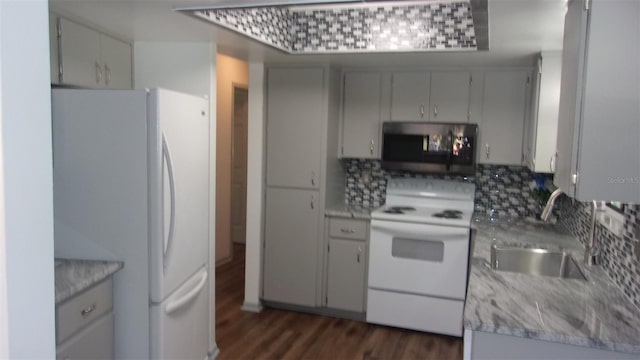 9880 SW 101st Pl, Ocala, FL 34481 - kitchen featuring white appliances, dark wood-style flooring, a sink, and tasteful backsplash