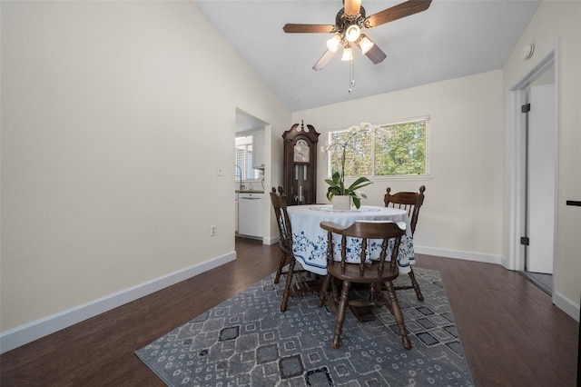 dining space featuring wood finished floors, baseboards, ceiling fan, and lofted ceiling