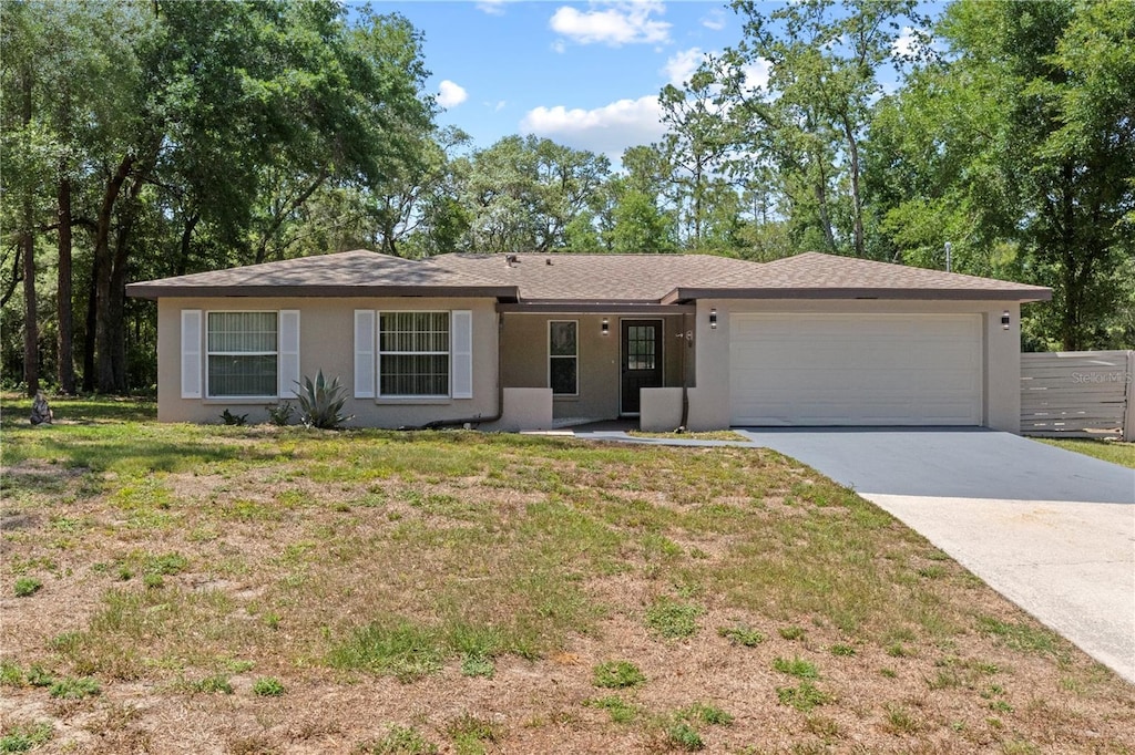 1933 W Albury Pl Unit 11, Dunnellon, FL 34434 - ranch-style house with concrete driveway, a garage, a front yard, and stucco siding