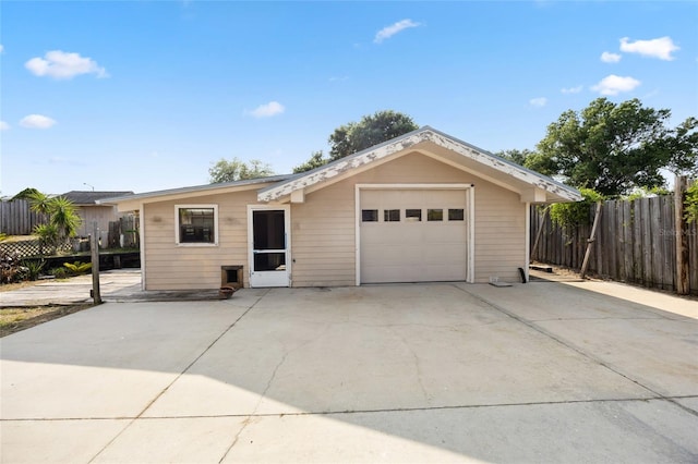 single story home featuring concrete driveway, a garage, and fence