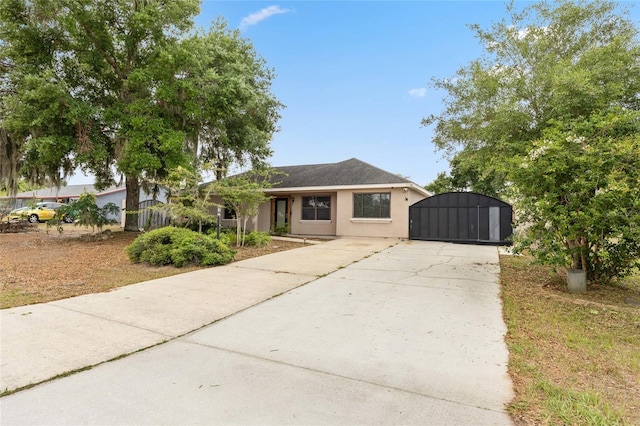 view of front of property with a gate, concrete driveway, stucco siding, and fence