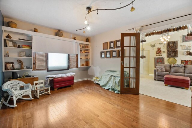 living area featuring hardwood / wood-style flooring, french doors, and baseboards