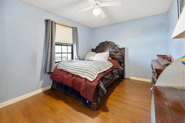 bedroom featuring wood finished floors, baseboards, and ceiling fan