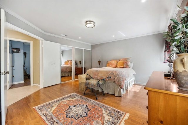 bedroom with light wood-style floors, ornamental molding, and baseboards