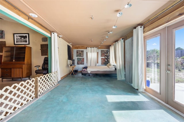 unfurnished sunroom featuring track lighting, plenty of natural light, and french doors