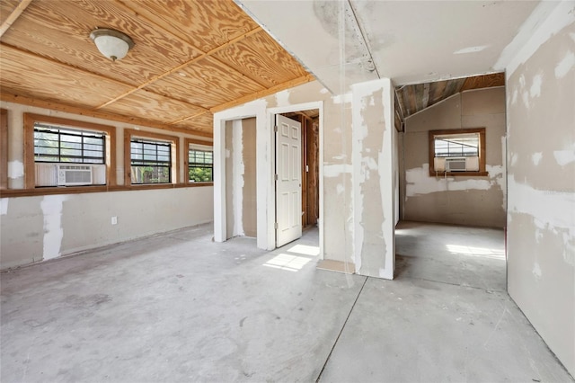 unfurnished room with cooling unit and unfinished concrete flooring