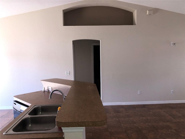 kitchen featuring baseboards and a sink