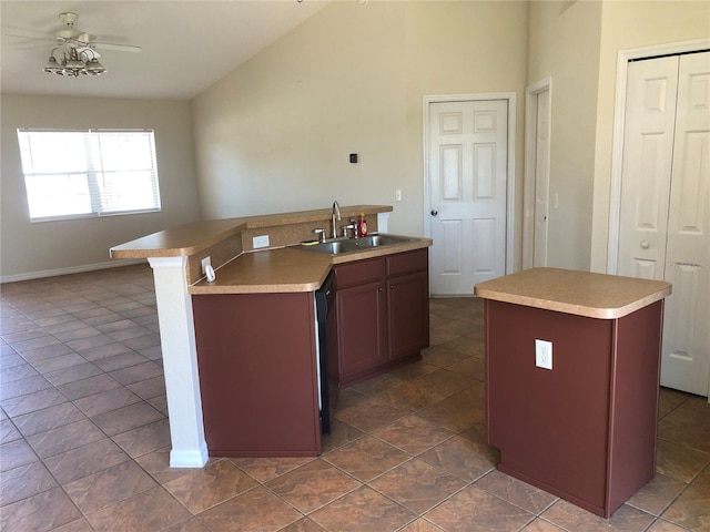kitchen with a kitchen island with sink, vaulted ceiling, dishwasher, a sink, and light countertops