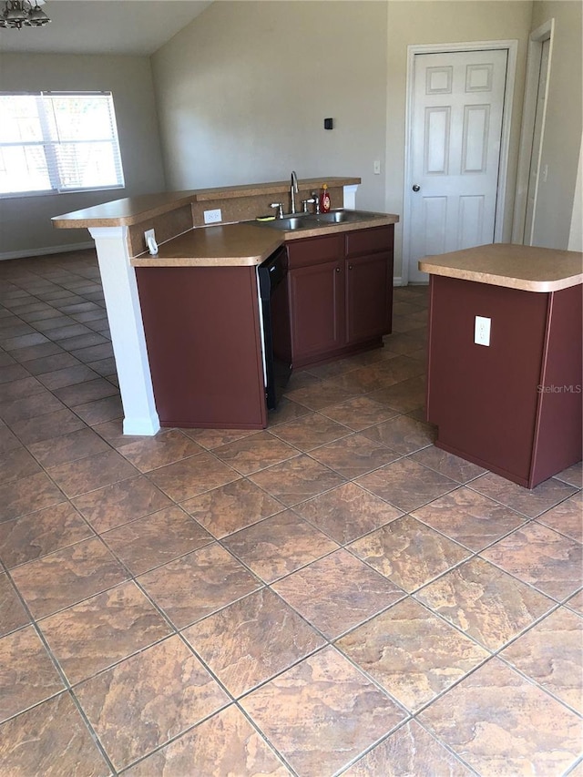 kitchen featuring a sink, black dishwasher, and a center island with sink
