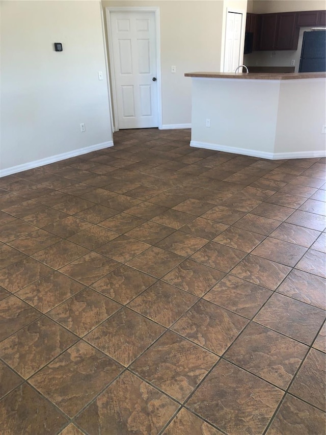 unfurnished living room with baseboards