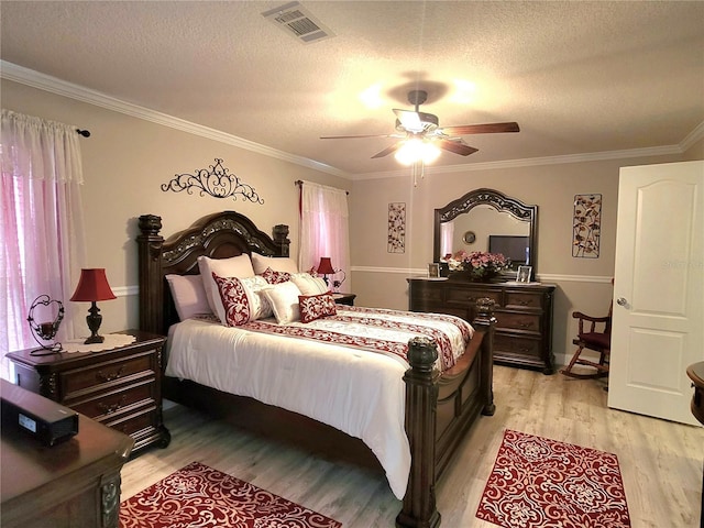 7030 SE 120th Ct, Morriston, FL 32668 - bedroom featuring a textured ceiling, visible vents, ornamental molding, and light wood-style floors