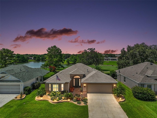 8545 SE 168th Kittredge Loop, The Villages, FL 32162 - view of front of home featuring a garage, driveway, a front lawn, roof with shingles, and a water view
