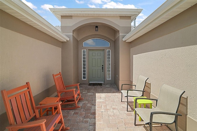8545 SE 168th Kittredge Loop, The Villages, FL 32162 - doorway to property featuring stucco siding and a patio area