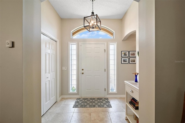 8545 SE 168th Kittredge Loop, The Villages, FL 32162 - entryway featuring light tile patterned flooring, a chandelier, arched walkways, and a textured ceiling