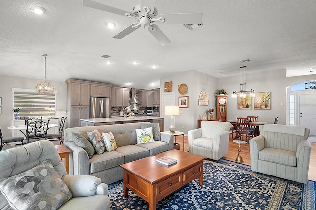 8545 SE 168th Kittredge Loop, The Villages, FL 32162 - living area with a chandelier, a ceiling fan, light wood-style floors, a textured ceiling, and recessed lighting