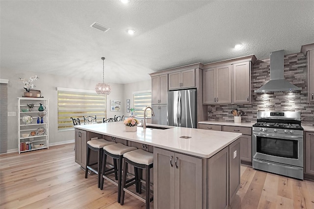8545 SE 168th Kittredge Loop, The Villages, FL 32162 - kitchen with wall chimney range hood, stainless steel appliances, light wood-style floors, backsplash, and a chandelier