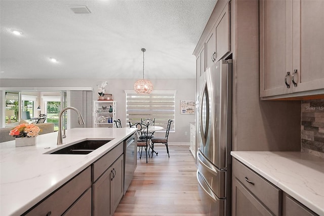 8545 SE 168th Kittredge Loop, The Villages, FL 32162 - kitchen with appliances with stainless steel finishes, light wood-style floors, gray cabinets, a chandelier, and hanging light fixtures
