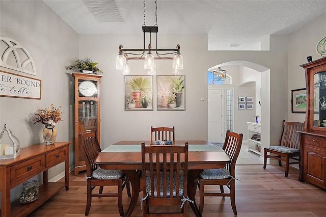 8545 SE 168th Kittredge Loop, The Villages, FL 32162 - dining space with arched walkways, wood finished floors, and a chandelier