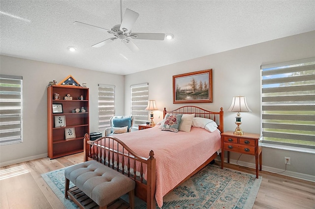 8545 SE 168th Kittredge Loop, The Villages, FL 32162 - bedroom featuring light wood finished floors, multiple windows, a textured ceiling, a ceiling fan, and recessed lighting