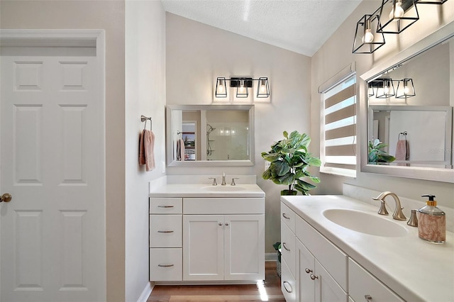 8545 SE 168th Kittredge Loop, The Villages, FL 32162 - bathroom featuring lofted ceiling, two vanities, a textured ceiling, and wood finished floors