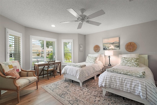 8545 SE 168th Kittredge Loop, The Villages, FL 32162 - bedroom featuring light wood-style floors, multiple windows, a textured ceiling, ceiling fan, and recessed lighting