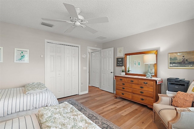 8545 SE 168th Kittredge Loop, The Villages, FL 32162 - bedroom with light wood finished floors, a textured ceiling, a closet, and ceiling fan