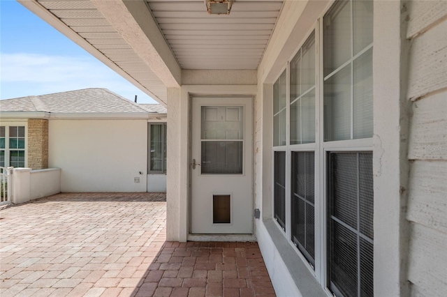 11146 SW 68th Ct, Ocala, FL 34476 - doorway to property featuring a patio, a shingled roof, and stucco siding